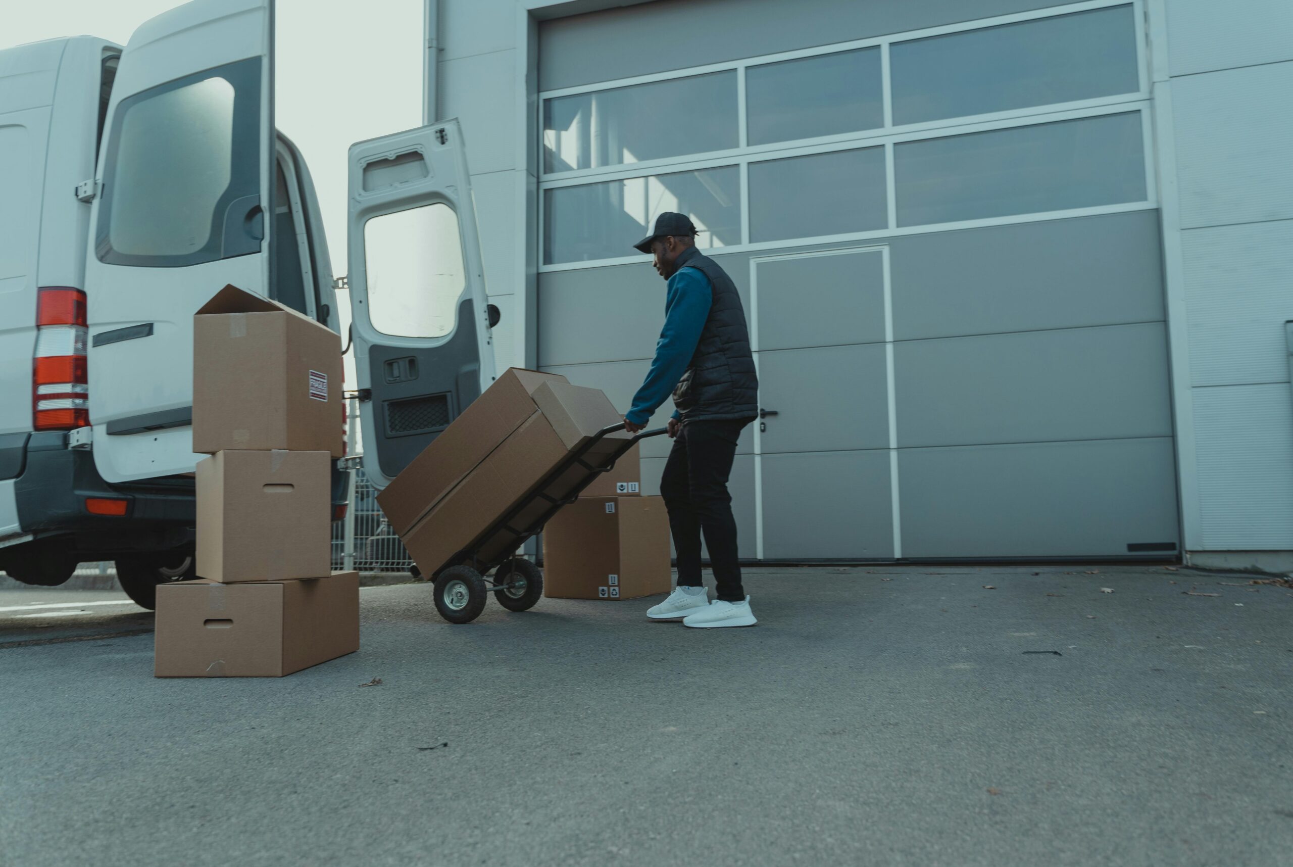 Delivery Man pulling a Trolley with Carton Boxes